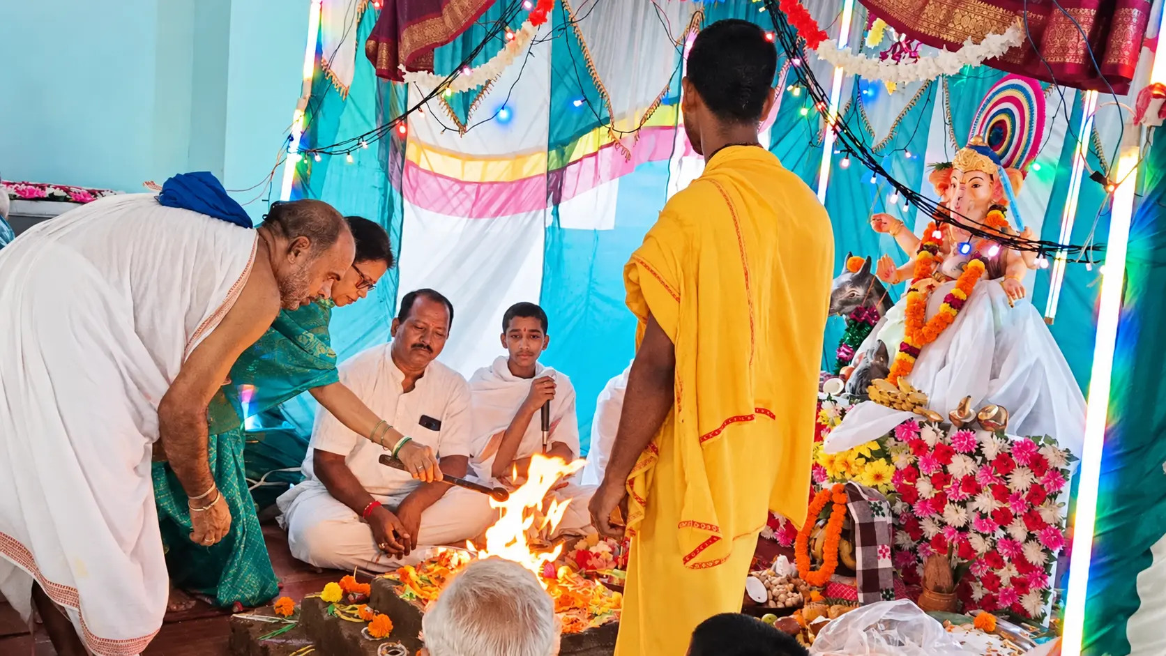Ganesh Puja ceremony with a ritual fire and flower-decorated idol